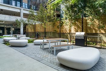 a courtyard with benches tables and chairs and a fountain